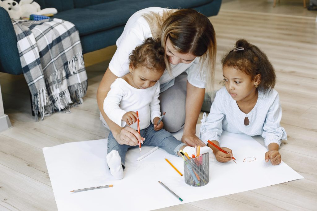 pexels-photo-8770584-8770584 A mother and her children enjoy creative drawing time at home, sharing quality moments on the floor.